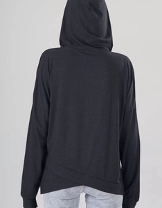 Detail des Kapuzenpullovers mit überlappendem Saumdesign und weicher Strickstruktur
