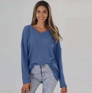 Detailed view of the waffle knit fabric and classic V-neck on a loose blue sweater