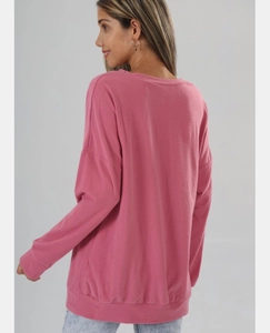 Vue détaillée du sweat-shirt rose à manches longues avec poignets côtelés et col rond