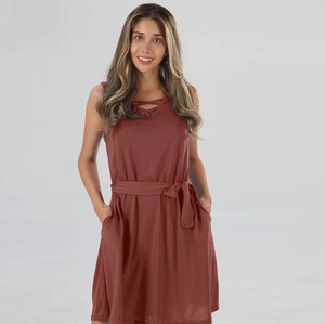 Détail de la robe sans manches rouge brique avec encolure croisée et taille à cordon réglable