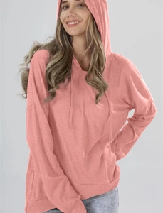 Nahaufnahme des korallenrosa Kapuzenpullovers mit verstellbarem Kordelzug und Stricktextur