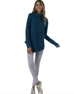 Détail d'un pull à col roulé bleu canard ample associé à un legging texturé gris