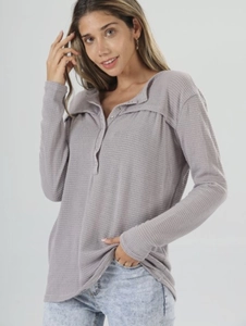 Detail of waffle knit fabric and button-down neckline on a loose long-sleeve mauve top