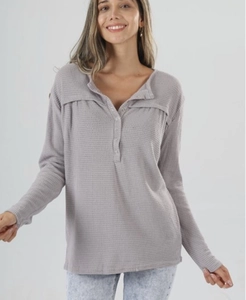 Close-up of lilac waffle knit top featuring henley button neck and shoulder pleat detail