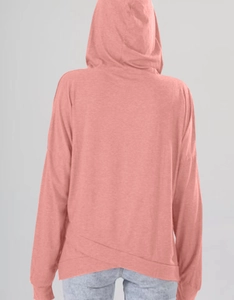Detail des überlappenden asymmetrischen Saums an einem korallenrosa Damen-Kapuzenpullover