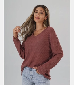 Detail of V-neck waffle knit top in dusty rose color with dropped shoulder design