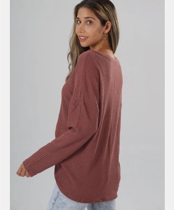Detail view of the rose pink waffle knit fabric texture and drop shoulder on the long sleeve top