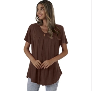 Detail of the V-neckline featuring three wooden buttons and pleats on a brown short sleeve top