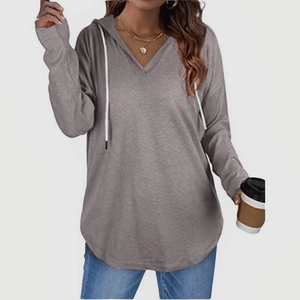 Detail of grey V-neck hoodie featuring white drawstrings and soft knitted texture