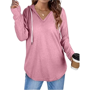 Detail of pink V-neck hoodie featuring drawstring hood and curved hem on model