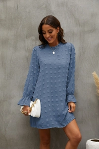 Detail of greyish blue dress featuring textured bubble embroidery and elegant ruffled cuffs