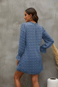 Detail of foggy blue dress with textured dots, ruffle neck and elastic frill cuffs