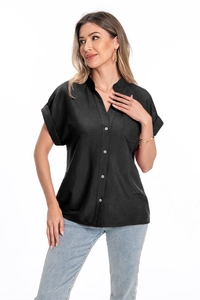 Close-up of black cotton linen shirt featuring white buttons and a chest pocket detail