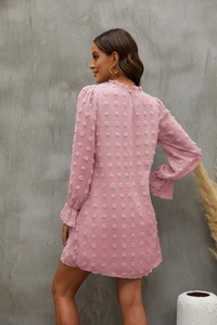 Detail of pink Swiss dot dress showing ruffled high neck and textured sleeve fabric