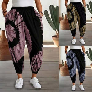 Detail of high-waisted harem pants with tie-dye patterns in purple, gold, and blue colors