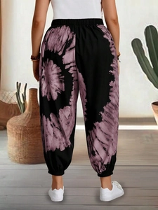 Rear view of loose fit tie-dye harem pants featuring elastic high waist and cuffed ankles