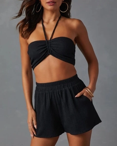 Detail of black pleated summer set showing textured halter top and high-waist shorts