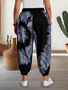 Rear view of women's high-waisted jogger pants featuring black and white tie-dye print