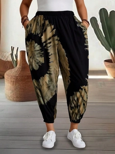 Relaxed bohemian black harem pants with sunflower tie-dye print and elastic cuffs