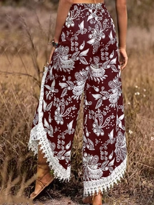 Détail du pantalon bohème bordeaux avec motif cachemire et ourlet à franges en dentelle