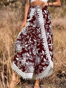 Détail du pantalon bohème bordeaux à motif paisley avec bordure en dentelle et franges