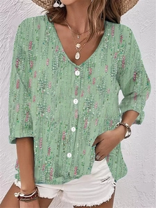 Detail of light green V-neck chiffon blouse featuring pink sequins and white buttons