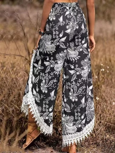 Vue détaillée du pantalon bohème à imprimé paisley avec dentelle blanche et glands