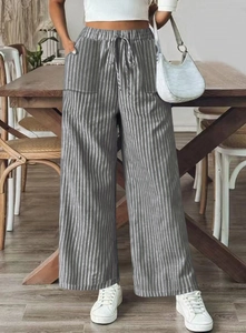 Detail of high-waist elastic waistband with adjustable drawstring on striped trousers