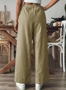 Back view of women's olive green striped wide-leg pants with elastic waist in a home setting