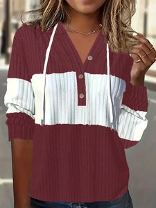 Détail du sweat à capuche patchwork bordeaux et blanc avec encolure boutonnée et texture côtelée