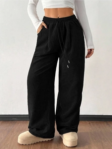 Detail of high waisted black corduroy trousers with drawstring and elastic waistband