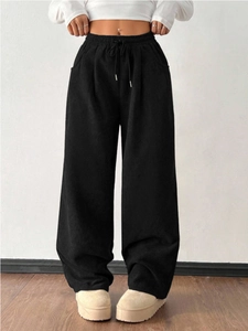 Detailed macro view of black corduroy trousers with elastic waistband and drawstrings