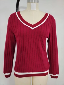 Detail of red V-neck knit top showing white contrast stripes on neckline and cuffs