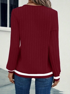 Detail of burgundy ribbed knit sweatshirt with white contrast stripes on cuffs and hem