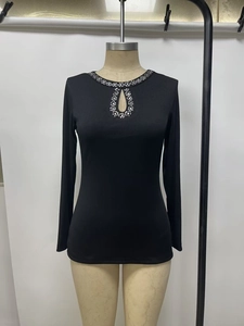 Detail of black ribbed long sleeve top with teardrop cutout and silver rhinestone accents