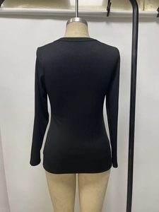 Detail of black ribbed long-sleeve top with rhinestones and round neckline on mannequin