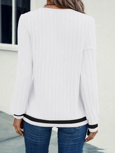 Detail view of white ribbed V-neck top with black stripe trim on hem and cuffs
