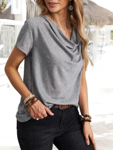 Dettaglio della maglia grigia a maniche corte con elegante scollo a cappuccio e texture