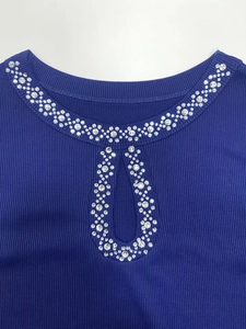 Detailed close-up of ribbed knit texture and rhinestone keyhole cutout on the blue top