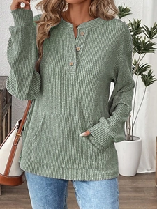Detail view of sage green ribbed knit henley top with wooden buttons and kangaroo pocket