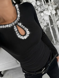 Detail of crew neck with rhinestone embellishment and teardrop cutout on ribbed black top