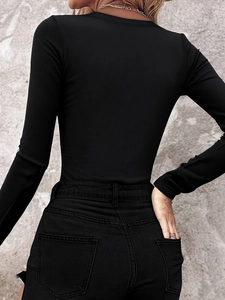 Rear view of black ribbed long-sleeve top showing vertical texture and slim fit