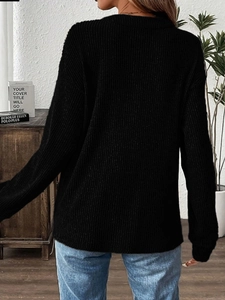 Back view of a black ribbed knit long sleeve sweater with a relaxed fit for women