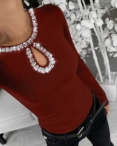 Macro shot of burgundy ribbed knit top featuring rhinestone neck and teardrop cutout detail