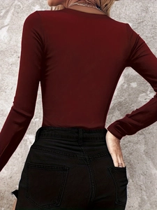 Detailed view of the burgundy ribbed knit fabric and slim-fit texture on the long sleeve top