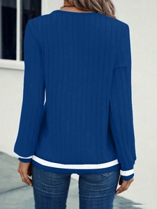 Detail view of the navy blue knit sweater with white striped cuffs and ribbed texture