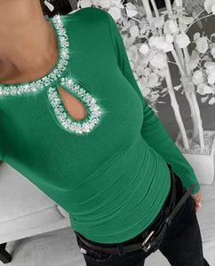 Close-up of green ribbed knit top with water-drop cutout and silver rhinestone neckline