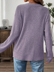 Close-up of dark purple knit fabric showing vertical ribbed texture and long sleeve detail