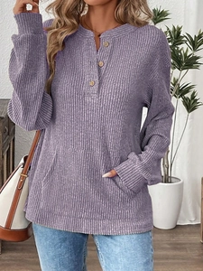 Detail of purple ribbed knit top showing henley button neck and kangaroo pocket