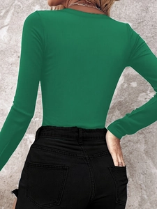 Close-up of emerald green ribbed long sleeve top featuring detailed knit texture and slim fit